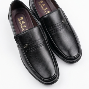 Zapatos mocasines negros de hombre sin cordones con suela de goma y detalle de costura frontal.