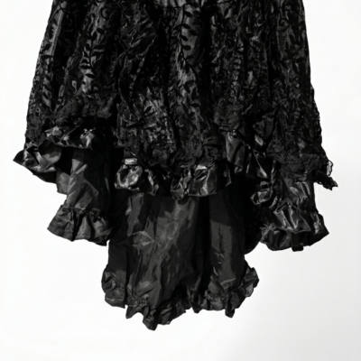 Falda corta negra de satén con capas de volantes y encaje floral negro, estilo gótico victoriano, talla única, fondo blanco profesional.